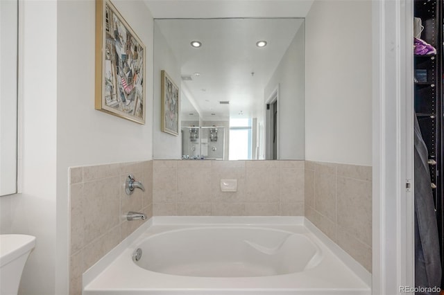 bathroom featuring shower with separate bathtub and toilet