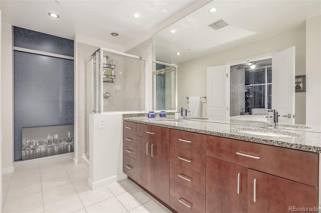 bathroom featuring tile patterned flooring, vanity, and a shower with shower door