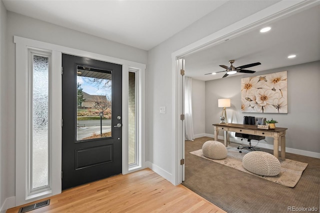 foyer with ceiling fan and light wood-type flooring