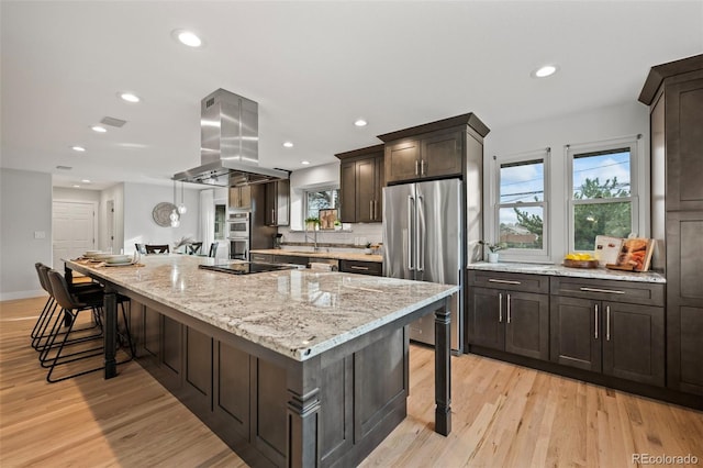 kitchen featuring sink, light hardwood / wood-style floors, a large island, island range hood, and stainless steel appliances