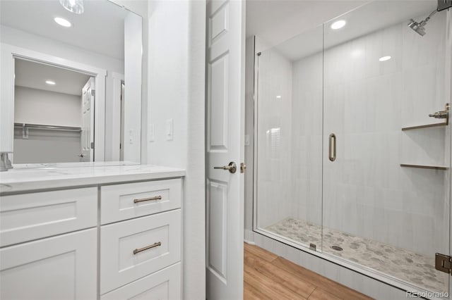 bathroom featuring hardwood / wood-style floors, vanity, and walk in shower