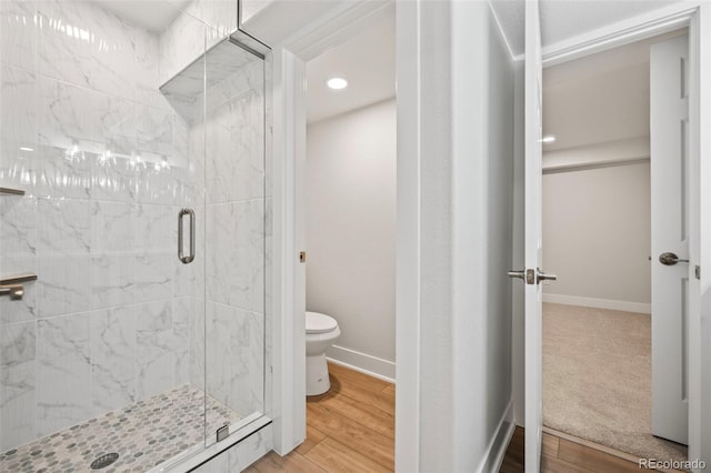 bathroom featuring a shower with door, wood-type flooring, and toilet