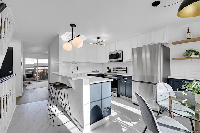 kitchen featuring kitchen peninsula, tasteful backsplash, stainless steel appliances, sink, and pendant lighting