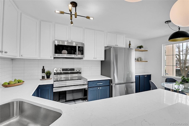 kitchen featuring white cabinets, decorative backsplash, blue cabinets, and stainless steel appliances