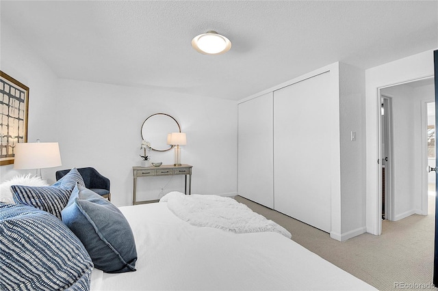 carpeted bedroom featuring a textured ceiling and a closet