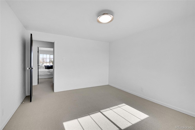 spare room featuring light colored carpet