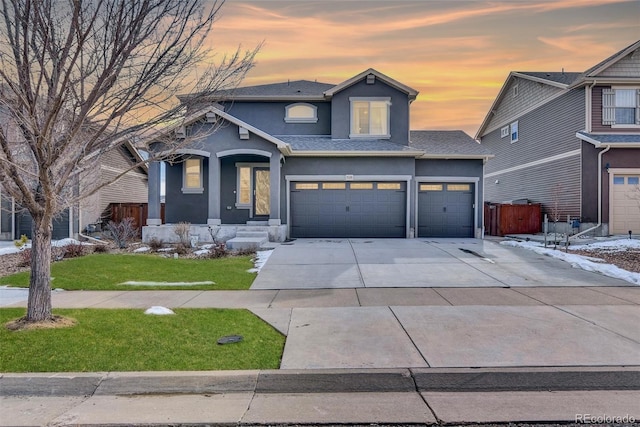 traditional home featuring a porch, concrete driveway, a yard, roof with shingles, and stucco siding