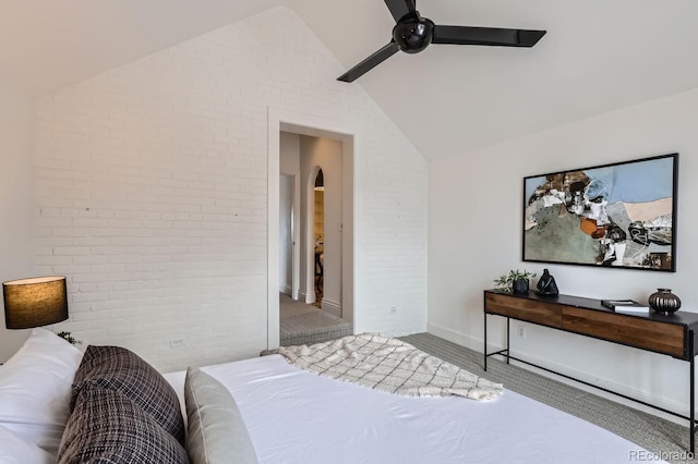 bedroom featuring lofted ceiling, ceiling fan, and brick wall