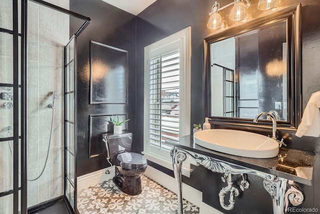 bathroom with tile patterned flooring, sink, a tile shower, and toilet