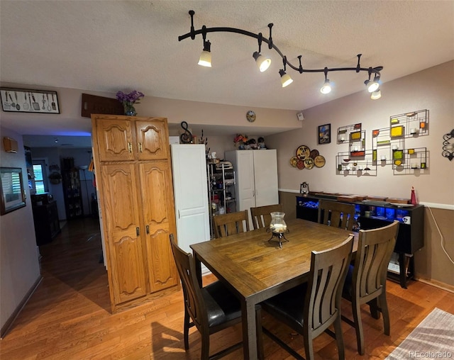 604 S Xenon Ct, Lakewood, CO 80228 - dining room with light wood-type flooring and a textured ceiling