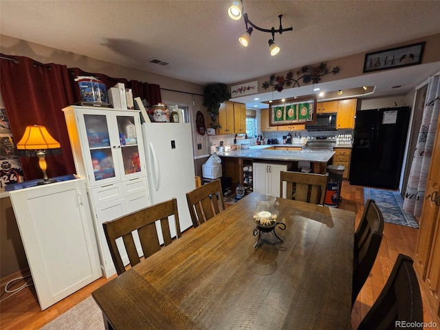 604 S Xenon Ct, Lakewood, CO 80228 - dining space with a textured ceiling and light wood-type flooring