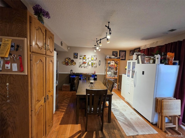 604 S Xenon Ct, Lakewood, CO 80228 - dining room with light wood-style flooring and a textured ceiling