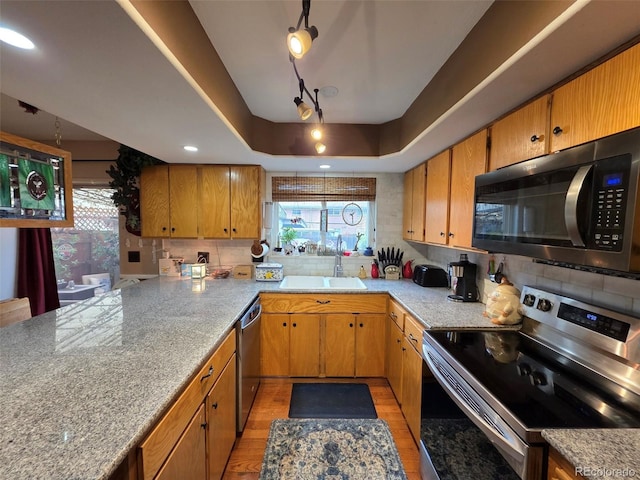 604 S Xenon Ct, Lakewood, CO 80228 - kitchen with appliances with stainless steel finishes, light wood-style flooring, plenty of natural light, and decorative backsplash