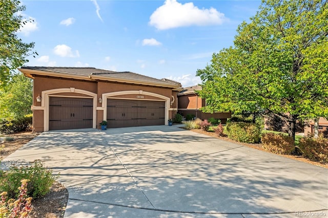 12477 Creekhurst Dr, Colorado Springs, CO 80921 - mediterranean / spanish house featuring concrete driveway, a garage, a tile roof, and stucco siding