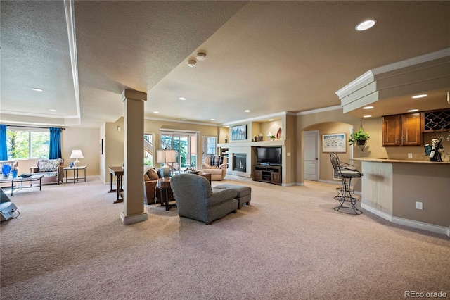 12477 Creekhurst Dr, Colorado Springs, CO 80921 - living room with a textured ceiling, light carpet, crown molding, arched walkways, and ornate columns