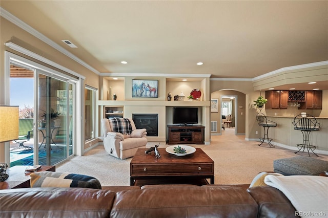 12477 Creekhurst Dr, Colorado Springs, CO 80921 - living room featuring light carpet, arched walkways, ornamental molding, baseboards, and recessed lighting