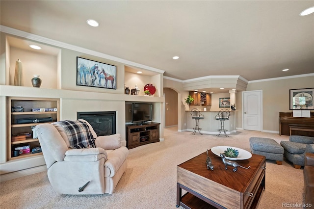 12477 Creekhurst Dr, Colorado Springs, CO 80921 - carpeted living room with crown molding, arched walkways, recessed lighting, a glass covered fireplace, and baseboards