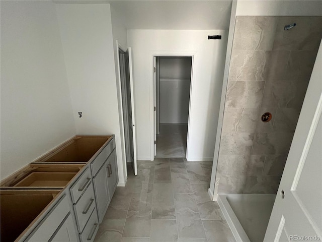 full bath featuring a tile shower and marble finish floor