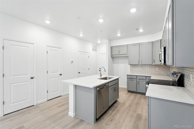 17115 W 91st Ln, Arvada, CO 80007 - kitchen with gray cabinetry, a sink, appliances with stainless steel finishes, light wood-style floors, and recessed lighting