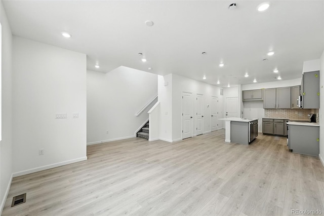 17115 W 91st Ln, Arvada, CO 80007 - kitchen featuring gray cabinetry, open floor plan, light wood-type flooring, recessed lighting, and backsplash