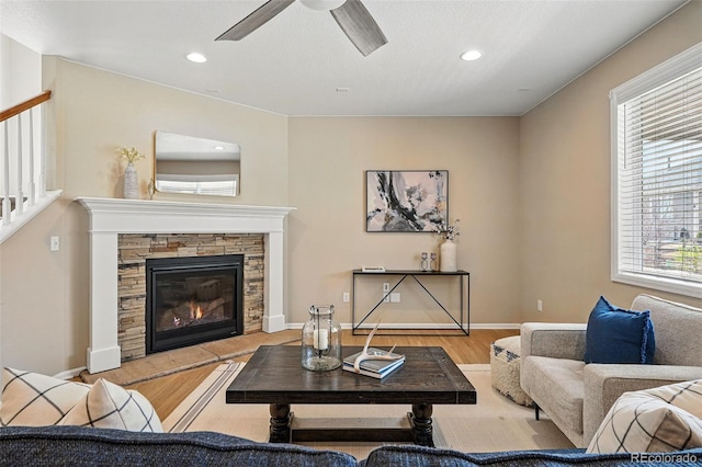 12623 Canoe St, Firestone, CO 80504 - living area featuring wood finished floors, a ceiling fan, recessed lighting, a stone fireplace, and stairway