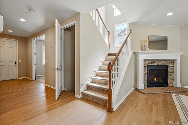 12623 Canoe St, Firestone, CO 80504 - staircase featuring wood finished floors, recessed lighting, and a stone fireplace