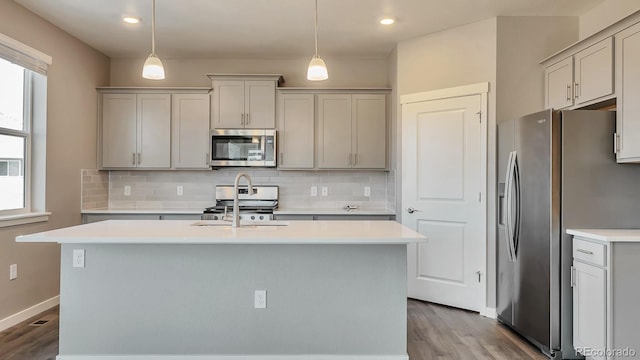 kitchen featuring gray cabinetry, hanging light fixtures, and appliances with stainless steel finishes