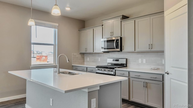 kitchen featuring backsplash, gray cabinets, sink, and appliances with stainless steel finishes