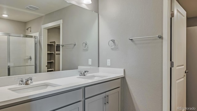 bathroom with a shower with door and vanity