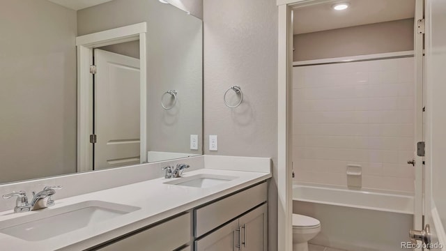 full bathroom featuring washtub / shower combination, vanity, and toilet