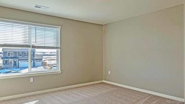 carpeted empty room featuring plenty of natural light