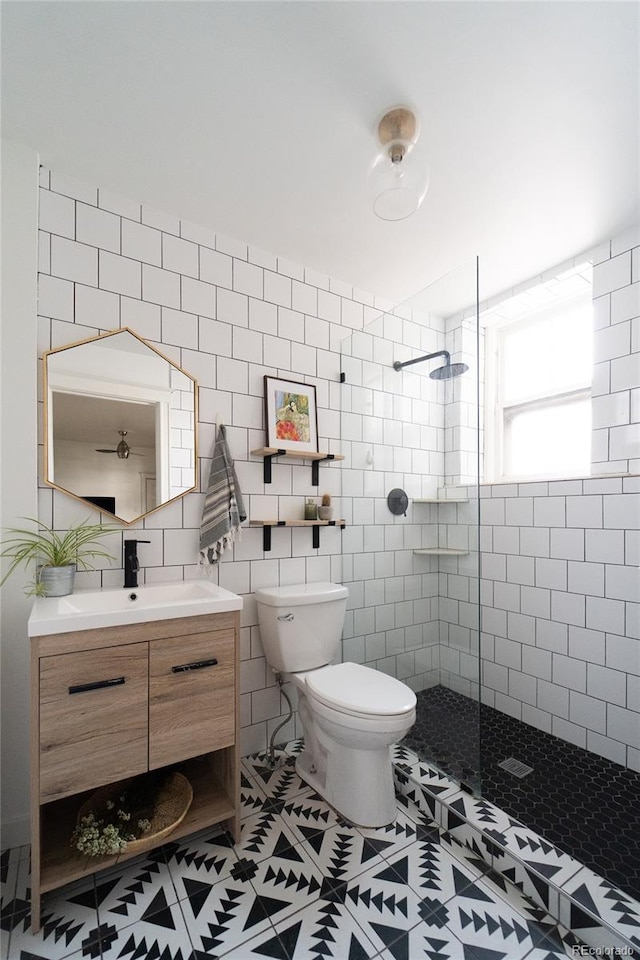 full bath featuring toilet, vanity, tile walls, and walk in shower