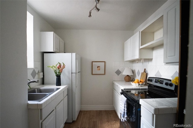 kitchen with a sink, open shelves, stainless steel electric range, tile countertops, and decorative backsplash
