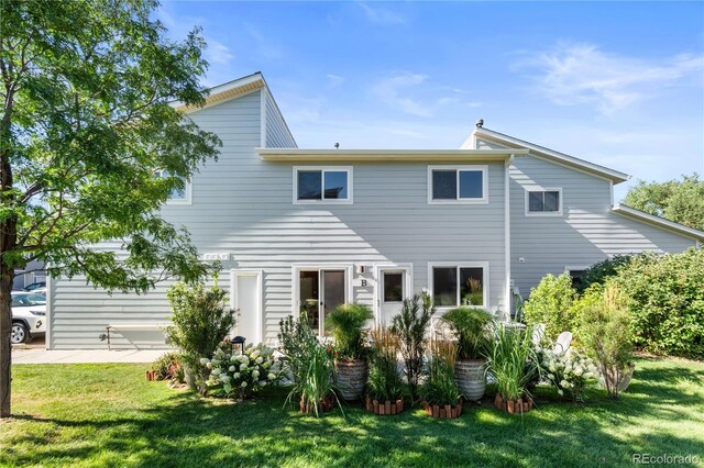 back of property with a patio area and a lawn