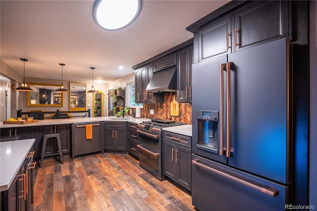 3125 Xenon St, Wheat Ridge, CO 80215 - kitchen with high end appliances, range hood, light countertops, dark wood-type flooring, and hanging light fixtures