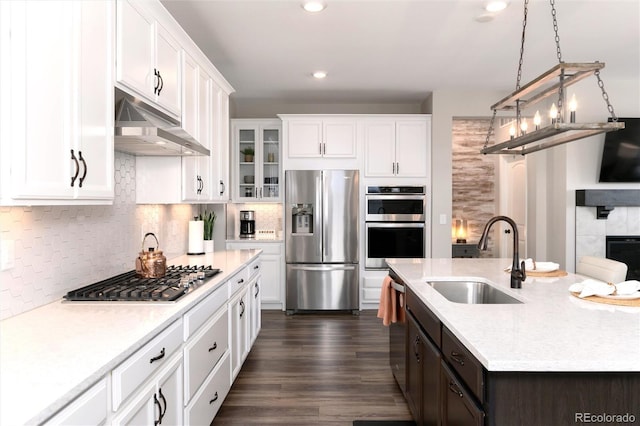 kitchen with decorative light fixtures, tasteful backsplash, sink, stainless steel appliances, and white cabinets