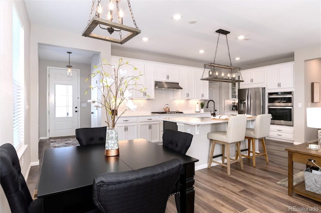 dining space featuring plenty of natural light, sink, and hardwood / wood-style floors