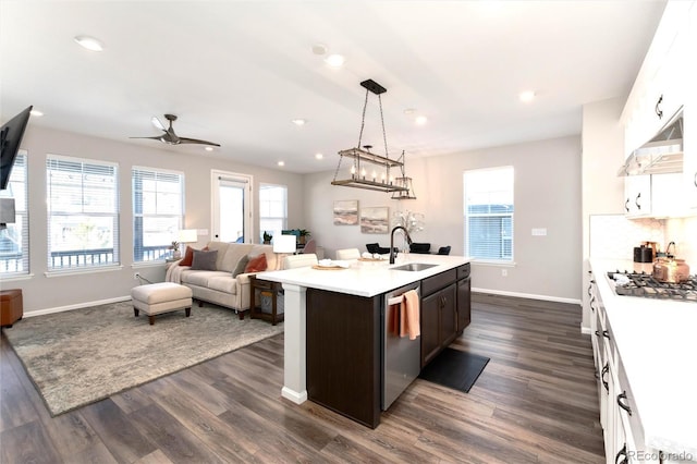 kitchen with appliances with stainless steel finishes, an island with sink, white cabinets, and sink