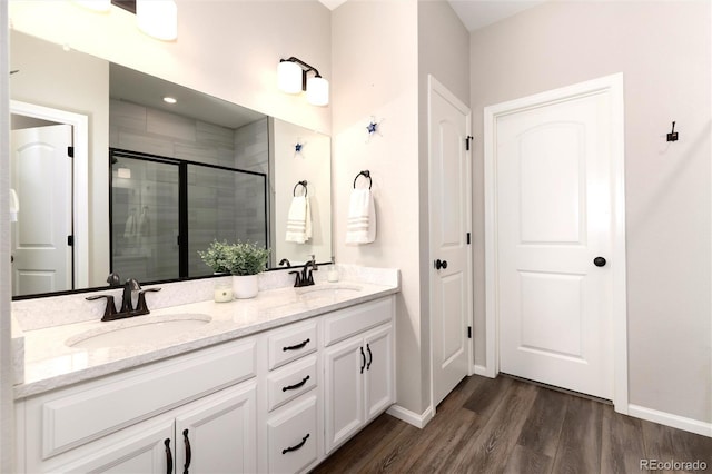 bathroom with vanity, wood-type flooring, and a shower with door