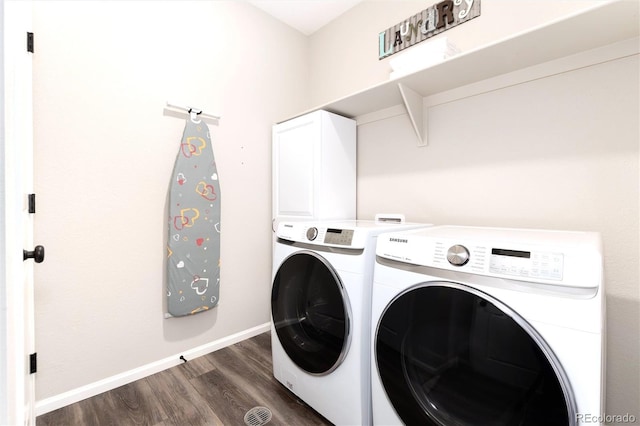 laundry area featuring washer and dryer, dark wood-type flooring, and cabinets