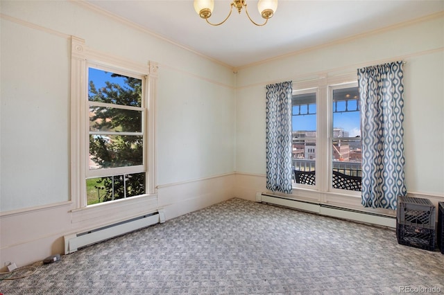 carpeted spare room with baseboard heating, crown molding, and a chandelier