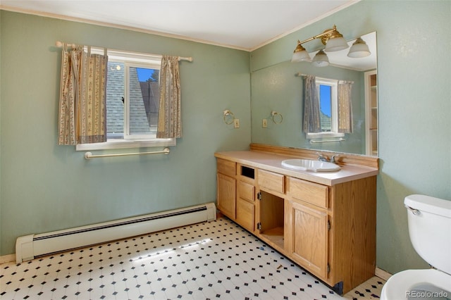 bathroom featuring toilet, vanity, crown molding, and a baseboard heating unit