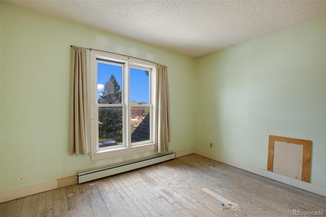 empty room featuring light wood-type flooring, a textured ceiling, and a baseboard radiator