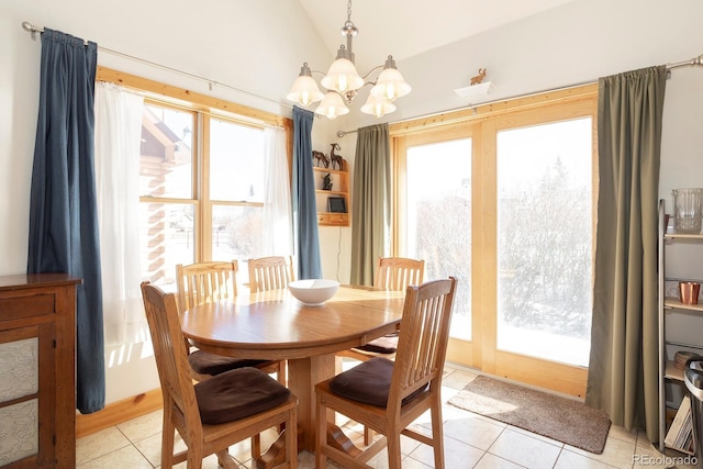 tiled dining space with a notable chandelier, a wealth of natural light, and vaulted ceiling