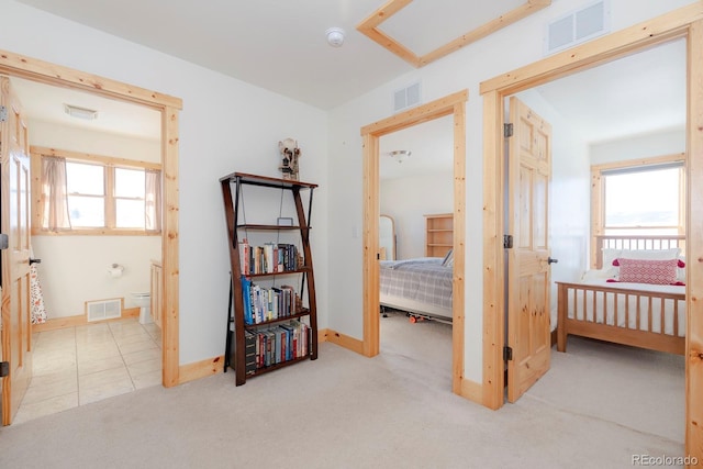 bedroom featuring light carpet and multiple windows