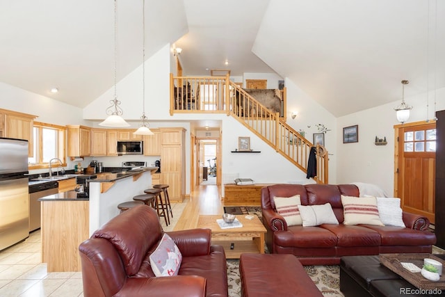 living area featuring high vaulted ceiling, stairway, and light tile patterned flooring