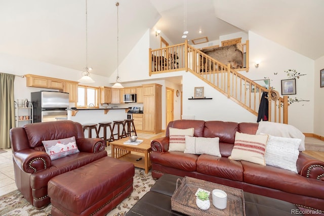 living area featuring stairs and high vaulted ceiling