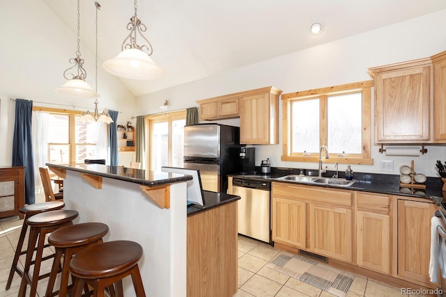 kitchen featuring a center island, decorative light fixtures, appliances with stainless steel finishes, vaulted ceiling, and a sink