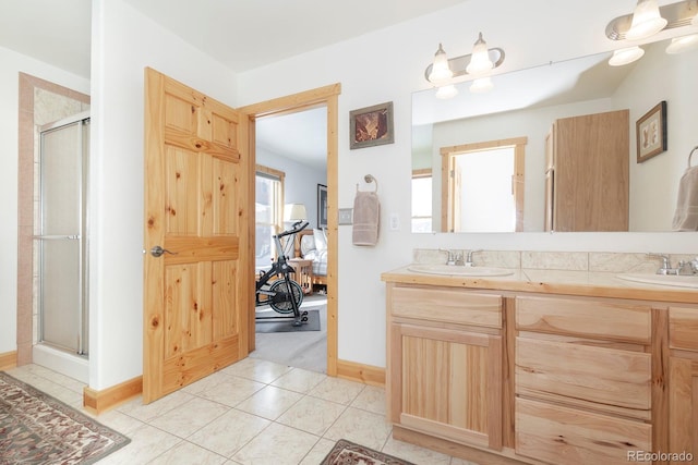 full bathroom with double vanity, ensuite bath, a sink, and tile patterned floors