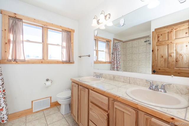 bathroom with toilet, double vanity, visible vents, and a sink